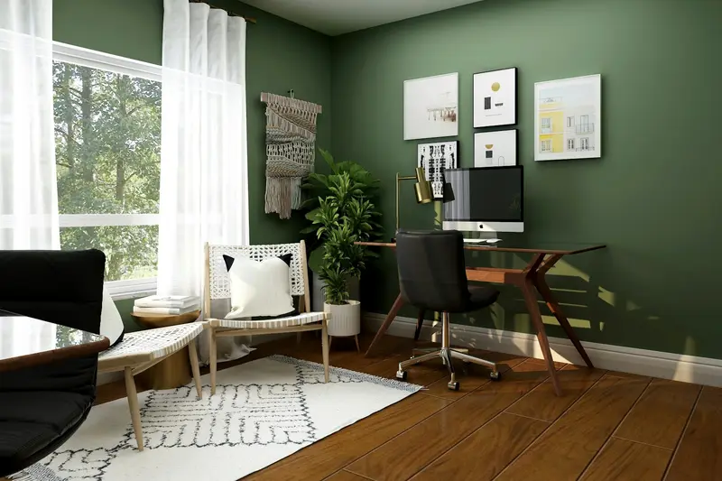 Home office with a wooden desk, green walls and a large window