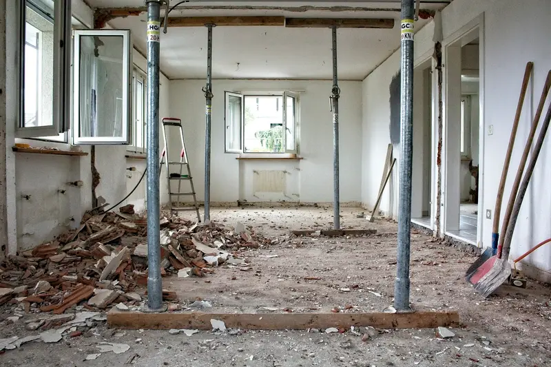 Room stripped to the structure during a renovation, with temporary steel supports